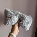 Close-up of light gray plush ear warmer headband featuring a brown leather decorative tag - Gray