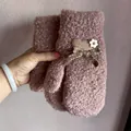 Dettaglio di muffole rosa in pile con texture peluche, decoro a cuore e fiocco carino - Cachi