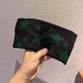 Detailansicht eines schwarzen Strickstirnbands mit grünen Sternen und weicher Textur - Dunkelgrün
