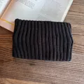 Close-up of solid black ribbed knit headband on vintage wood and book background - Black