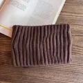Macro detail of dark brown ribbed knit headband on a wooden background with magazine - Coffee