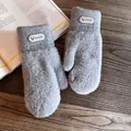 Close-up of light gray plush mittens with a deer logo patch on dark wood background - One Size / Gray