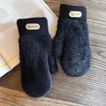 Detail of plush black knit mitten with premium leather deer logo patch on wooden desk - One Size / Black
