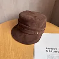 Detailed view of dark brown suede flat top hat with a gold heart metal emblem - M (55-59cm) / Coffee