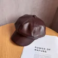 Detail of a dark brown PU leather newsboy hat showing soft texture and stitching - M (55-59cm) / Coffee