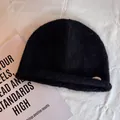 Detail of black knit beanie featuring fuzzy mohair texture and a small metal logo tag - M (55-59cm) / Black