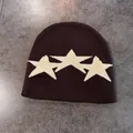 Detailed view of the dark brown knitted beanie featuring white star jacquard patterns - M (52-58cm) / Coffee