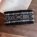 Close-up of winter knitted headband with Nordic snowflake pattern on wooden background - Black Snowflake Style / Black