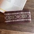 Close-up of knit winter headband featuring white geometric and green snowflake patterns - Dark Brown Jacquard Style / Coffee