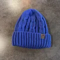 Dettaglio del berretto blu a maglia intrecciata con trama spessa e toppa a stella in pelle - Elastico / Blu Zaffiro