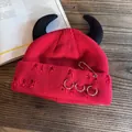 Dettaglio del cappello punk rosso con corna da demone nere e spille da balia in argento - Rosso