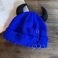 Detail of blue distressed knit beanie with black devil horns and silver metal safety pins - Sapphire Blue