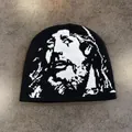 Detailed view of black knitted beanie with white jacquard face pattern and soft texture - M / Black