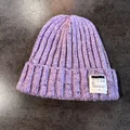 Detail shot of purple chunky knit beanie with colorful speckles and woven brand label - Purple / Elastic