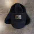 Détail du bonnet d'aviateur noir en maille pelucheuse avec écusson en cuir et texture douce - M(55-59cm) / Noir