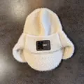 Détail du bonnet en maille blanche avec texture duveteuse et écusson en cuir brun - M(55-59cm) / Poche zippée