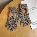 Primer plano de guantes de felpa de leopardo con lazo sobre escritorio de madera - Café