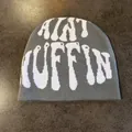 Berretto in maglia grigia con scritta jacquard AINT MUFFIN bianca su tavolo di legno - M / Grigio