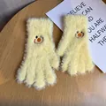 Close-up of yellow knitted plush gloves featuring an embroidered cartoon smiley face pattern - One Size / Yellow