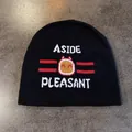 Close-up of black knit beanie featuring white ASIDE lettering and red cartoon fireball jacquard - Black