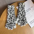 Nahaufnahme von Plüschhandschuhen mit Leopardenmuster und flauschiger Textur - Grau