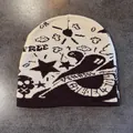 Detail of jacquard knit beanie featuring skull and star patterns in street style - M / Coffee