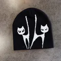 Detailansicht der weichen Stricktextur und des weißen Katzen-Jacquardmusters auf der Mütze - M (52-58cm) / Schwarz