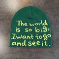 Close-up of dark green knitted beanie with yellow jacquard letter embroidery detail - Green