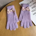 Detail of purple knitted gloves with pink striped bow and small golden Baby metal tag - Purple