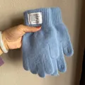 Detailansicht der hellblauen flauschigen Strickhandschuhe mit dekorativem weißem Webetikett - Blau