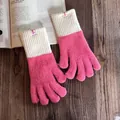 Detail von rosapinken Strickhandschuhen mit cremefarbenen Rippbündchen auf Holztisch - Fuchsia