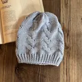 Dettaglio del cappello in maglia a trecce azzurro con trama spessa e risvolto a costine - Blu