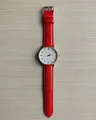 Detail view of quartz watch featuring red leather strap and rose gold minimalist dial - Red
