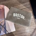 Gros plan d'un bandeau en maille côtelée avec texte Boston 1630 sur du bois - Kaki