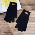 Detailed texture of black thermal knit gloves with a decorative fashion leather patch - One Size / Black