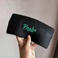 Close-up of black ribbed knit headband with green Boston EST.1987 embroidery detail - Black