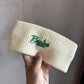 Macro detail of cream knit headband featuring green Boston EST 1987 embroidery - Off White