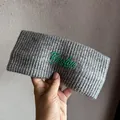 Detail of grey knitted headband with green Boston EST.1987 embroidery and ribbed texture - Gray