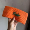 Close-up of orange ribbed knit headband with green Boston 1987 embroidery detail - Orange
