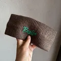 Detail of ribbed knit brown headband with green Boston EST.1987 rubber text - Coffee