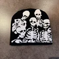 Dettaglio della trama jacquard con teschi su un berretto in maglia nera stile gotico - M / Nero + Teschio Bianco