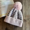 Detailed close-up of pink and grey houndstooth knit beanie with a large fluffy pom-pom - M (54-59cm) / Pink