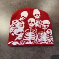 Close-up of red knitted beanie featuring white skull patterns for Halloween party style - M / Red