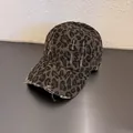 Dettaglio del cappello leopardato vintage con bordi strappati e stile retrò y2k - Regolabile / Grigio