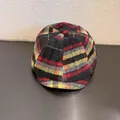 Detailopname van de vintage wollen newsboy pet met een klassiek rood en geel ruitpatroon - Maat M (55-59cm) / Grijs Rood Geruit