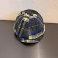 Detail van een geruite newsboy cap met geel en blauw patroon en een knoop aan de bovenkant - Maat M (55-59cm) / Grijs Geel Geruit