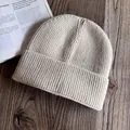 Gros plan sur la texture du bonnet en maille côtelée et le bord plié sur bois - M / Poche zippée