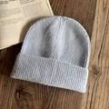 Texture dettagliata di un berretto in maglia azzurra su un tavolo di legno naturale - M / Grigio chiaro