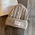 Flat lay of khaki cable knit beanie with thick fold-over cuff on rustic wood background - M (55-59cm) / Khaki