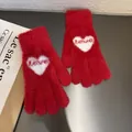 Detailed close-up of soft plush red knit gloves with white heart and love pattern - One Size / Red